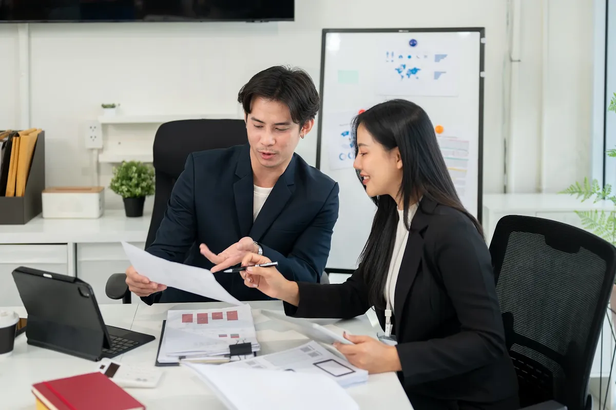 Consultant explaining MOM and work pass documents to an employer